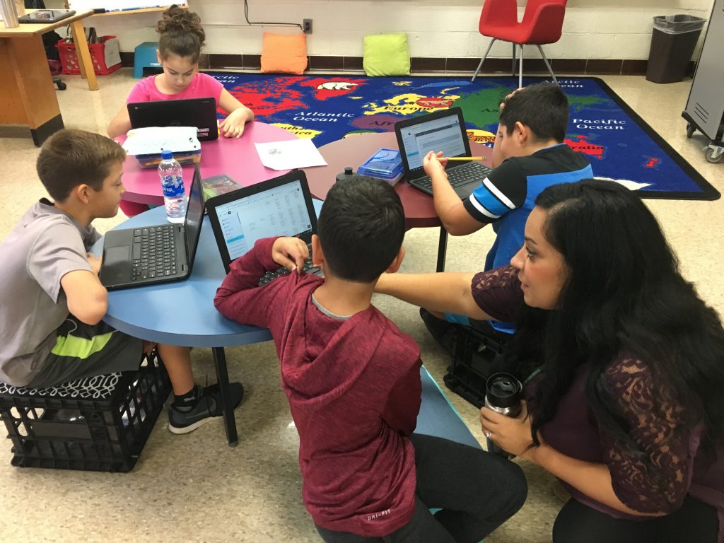 teacher helping a student using a computer