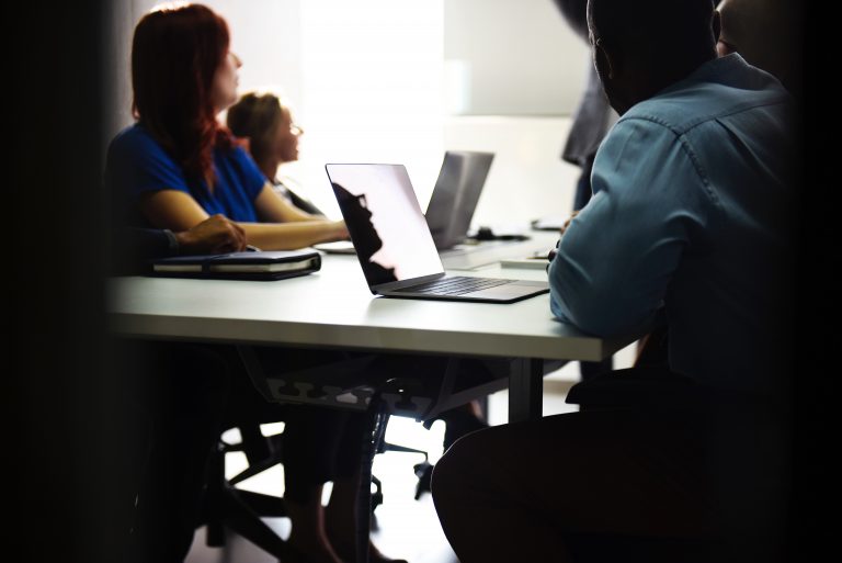 adults sitting in chairs looking at the board