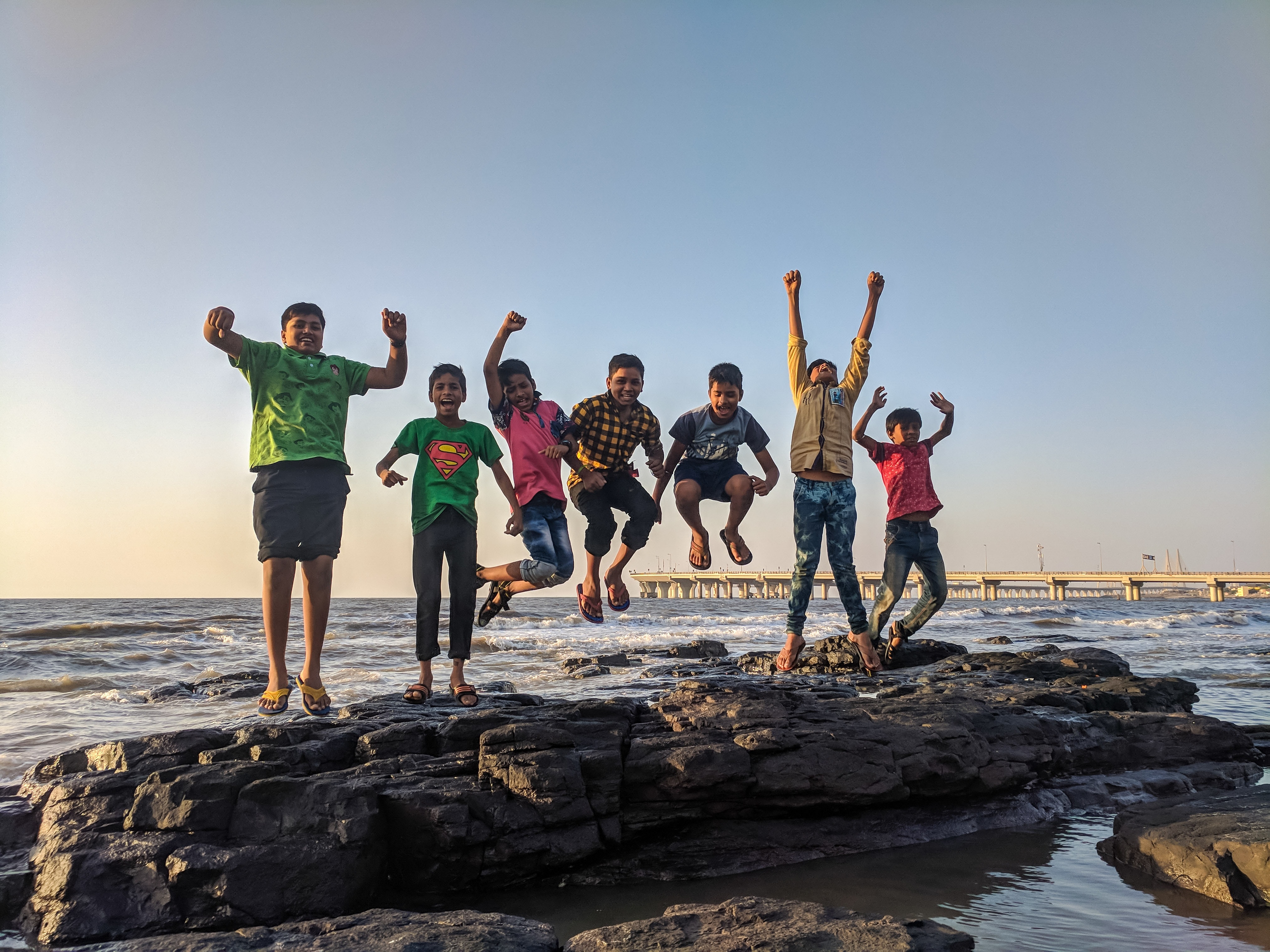 kids jumping up high on the beach