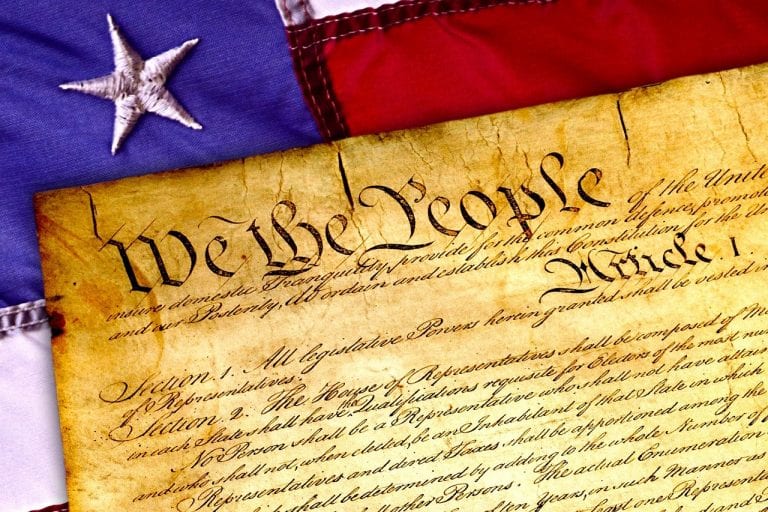 constitution on parchment paper laying on the american flag