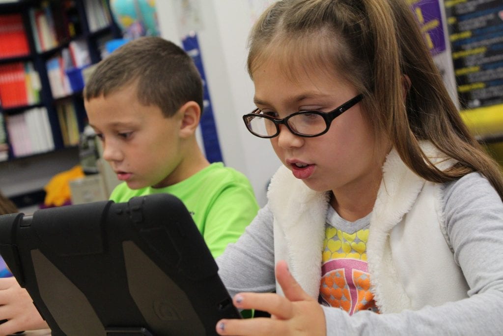 two students using ipads in class
